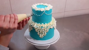 تزیین کیک دوطبقه آبی با شکوفه های بهاری